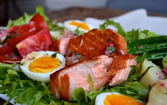 1. Этап. Нисуаз с лососем: Добавьте картошку, порезанную половинками, яйца, помидоры, спаржу, лосось сверху (вилкой разделите его на несколько кусочков). Полейте салат заправкой. Можете подавать.