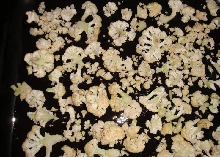 1. Этап. Цветная капуста с яйцом и помидорами: Для начала разделяем цветную капусту на соцветия. Затем смазываем противень маслом и выкладываем на него капусту.