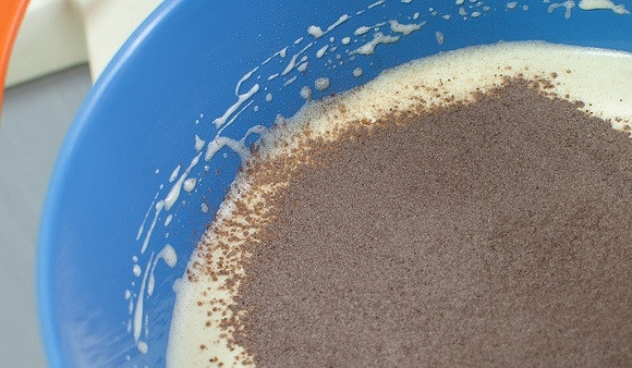 1. Этап. Простой шоколадный бисквит: 6. Добавьте к яичной массе половину смеси сухих ингредиентов, перемешайте лопаткой.