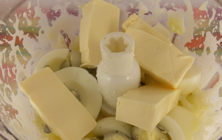 1. Этап. Закуска из рыбных консервов: Яйца отварите, остудите и очистите от скорлупы. Добавьте их дольками к луку вместе с сыром. Ещё раз измельчите смесь при помощи блендера.