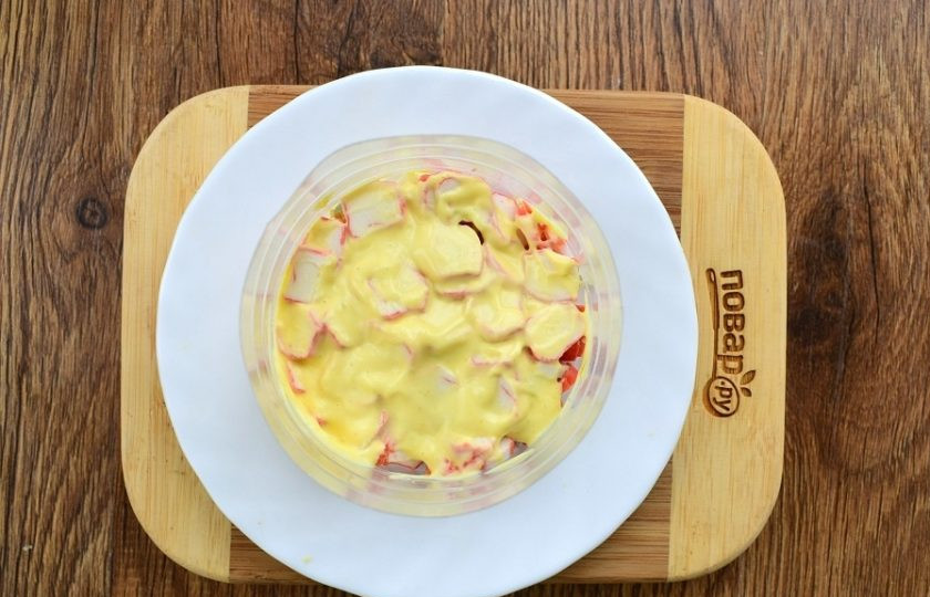 1. Этап. Крабовый салат с черносливом: Поставьте сервировочное кольцо на блюдо и выкладывайте ингредиенты слоями. 1-й слой: крабовые палочки, смажьте майонезом, немного прижмите.