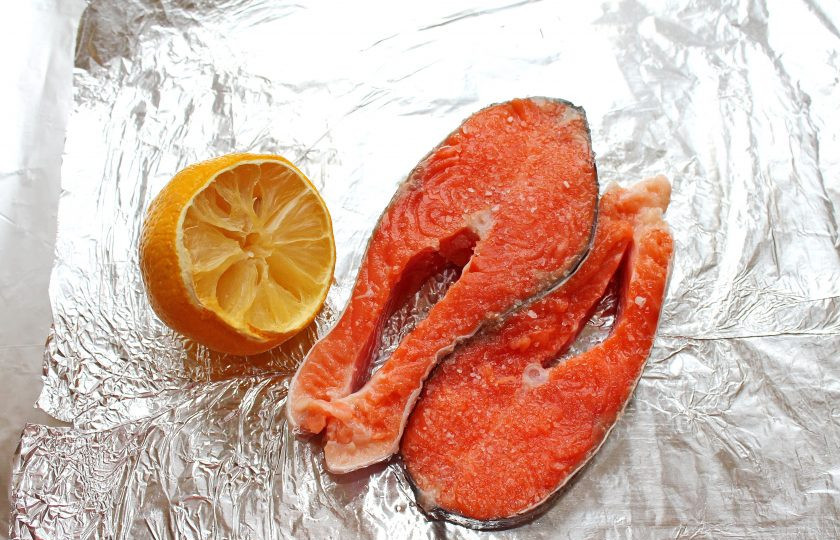 1. Этап. Форель запеченная в сметане: Возьмите лист фольги для запекания, чтобы в нее можно было завернуть рыбу, и смажьте ее растительным маслом. Сбрызните форель сверху лимонным соком, посолите и поперчите с двух сторон.