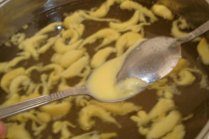 1. Этап. Суп куриный с яйцом: 6. Отправить в бульон порезанную курицу. Тесто слегка подсолить по вкусу и сформировать клецки. Двумя ложками набирать тесто и отправлять прямо в кастрюлю. Через 5-10 минут суп куриный с яйцом в домашних условиях можно украсить зеленью и подавать к столу.