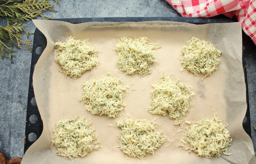 1. Этап. Сырные чипсы из сыра: Противень застелите силиконовым ковриком или пергаментом и разложите сырную массу небольшими кучками на расстоянии друг от друга, так как сыр поплывет при запекании.