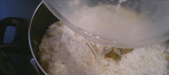 1. Этап. Плов из окорочков: 6. Моем рис несколько раз, после чего отправляем его на сковороду. Засыпаем сверху мяса с овощами.