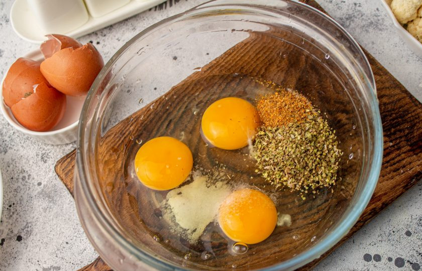 1. Этап. Запеканка из кабачков, брокколи и цветной капусты: Яйца вбейте в подходящую посуду, добавьте по вкусу соль и черный молотый перец. Для аромата добавьте сушеный орегано. Если не нравится орегано, то не добавляйте или добавьте те специи, которые нравятся вам. Перемешайте массу венчиком, чтобы соединились белки с желтками и приправами.