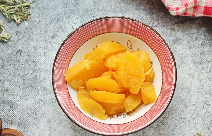 1. Этап. Апельсиновые конфеты: С апельсина срежьте немного цедры для украшения. Срежьте острым ножом корку с апельсинов и мелко порежьте. Вырежьте мякоть между пленками, выложите в миску вместе с соком.