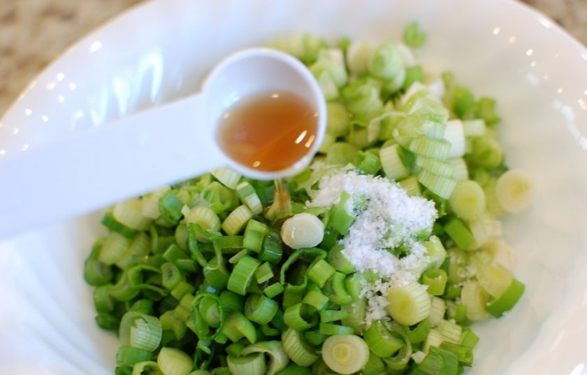 1. Этап. Лепешки на сковороде с зеленым луком: 3. Промойте зеленый лук, порежьте его, посолите и добавьте 1 столовую ложку кунжутного масла, перемешайте и отложите.