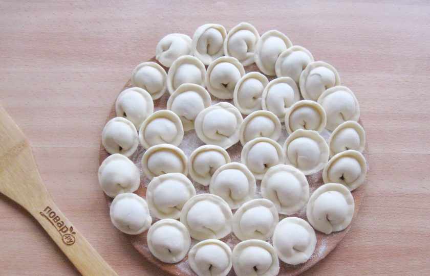 1. Этап. Пельмени из свинины и курицы: Слепите края теста, как на вареники. После соедините концы. Таким образом сформируйте все пельмени.