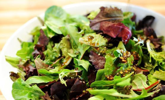 1. Этап. Горячий салат с говядиной: Листья салата положить в миску и полить 3/4 части заправки. Перемешать.