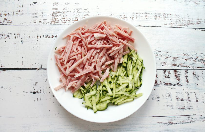 1. Этап. Салат Острые чувства: Ветчину и огурцы нарежьте соломкой и выложите в салатник.