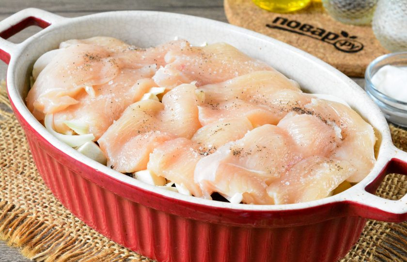 1. Этап. Куриные грудки с картошкой и грибами: Куриные грудки сполосните, мясо нарежьте как на отбивные, выложите в форму. Курицу посолите и поперчите по вкусу.