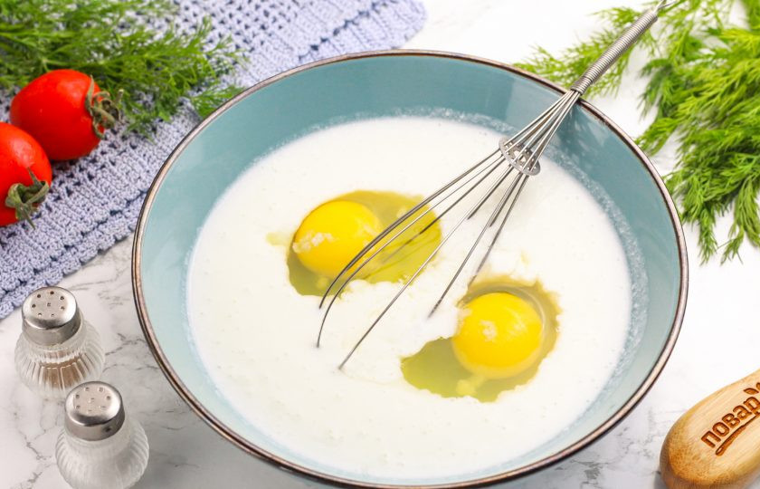 1. Этап. Блины с начинкой из баклажанов: Кефир любой жирности вылейте в миску или салатник и вбейте туда же куриные яйца, всыпьте щепотку соли. Взбейте венчиком.