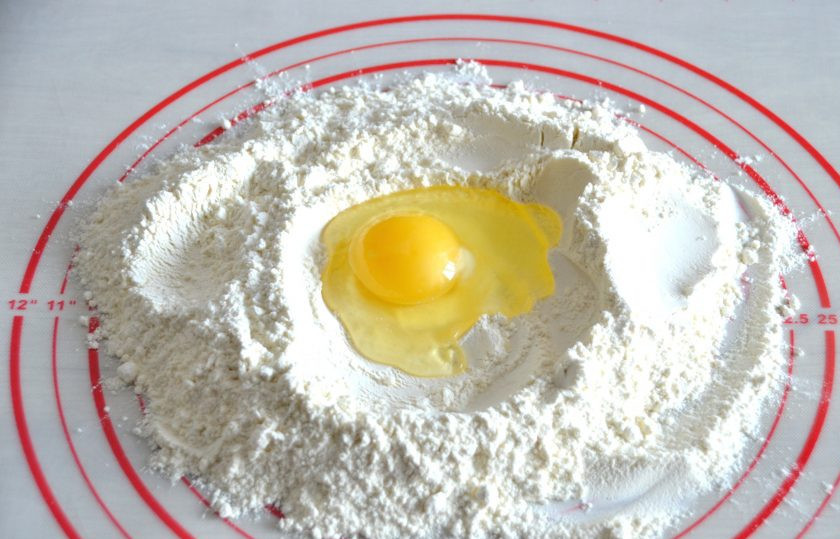 1. Этап. Классическая итальянская паста: Сделайте в муке углубление, вбейте 2 яйца. Замесите тесто, оно будет довольно плотным.