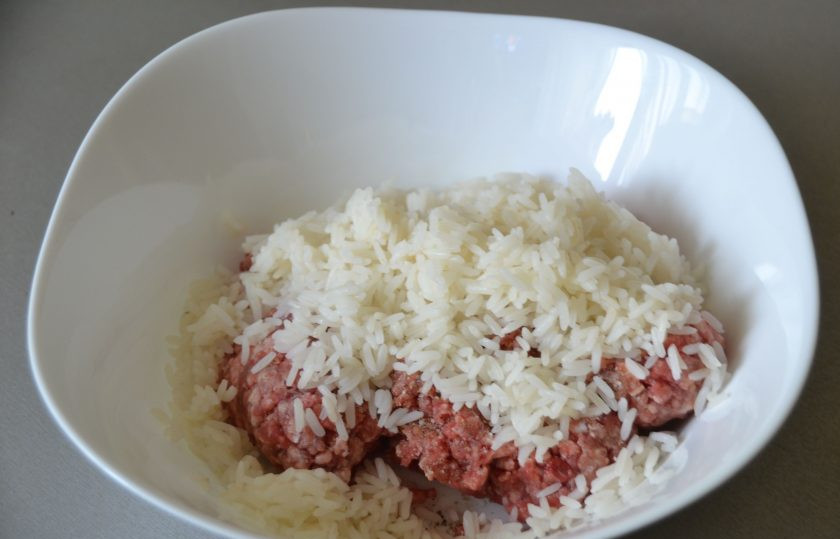 1. Этап. Голубцы по-цыгански: Добавьте рис в мясной фарш, посолите, поперчите, перемешайте.