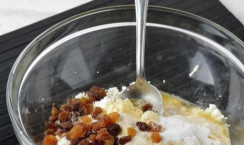 1. Этап. Запеканка из творога на сковороде: Изюм промойте и добавьте к остальным ингредиентам. Также в миску положите половину от всей манной крупы, соду и сметану. Все тщательно перемешайте.