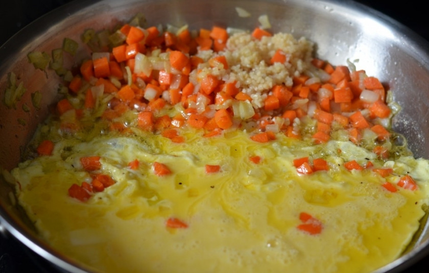 1. Этап. Рис с морковкой и луком на сковороде: 2. В данном случае этот простой рецепт риса с морковкой и луком на сковороде дополнен также взбитыми с небольшим количеством молока яйцами. Их нужно вылить на край сковороды, предварительно отодвинув овощи. Жарить буквально 1-2 минуты, чтобы омлет немного схватился.