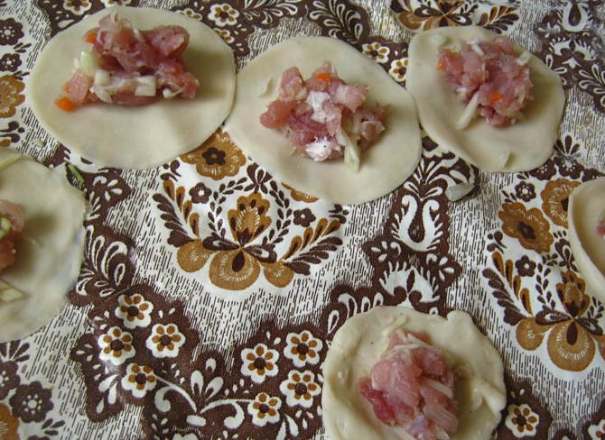 1. Этап. Пельмени со свининой и капустой: 3. Отдохнувшее тесто разделяем на кусочки, из каждого раскатываем тонкий круг и стаканом вырезаем кружочки желаемого размера, внутрь каждого кладем начинку.