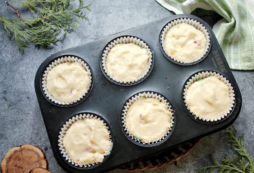 1. Этап. Кукурузные кексы с цукатами: Бумажные формочки выложите в форму для маффинов и разложите тесто на 3/4 высоты формочек.