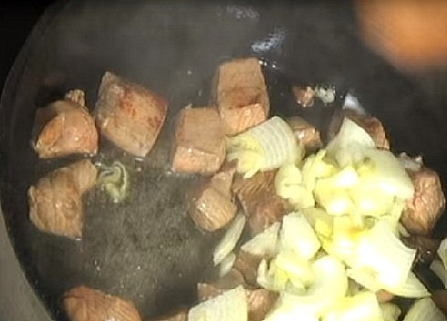 1. Этап. Бастырма: Добавим лук, нарезанный четвертькольцами. Перемешиваем и обжариваем с мясом до прозрачности.