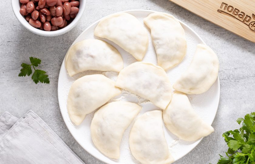 1. Этап. Вареники с фасолью: Защипните края, сформируйте вареники и выложите их на присыпанную мукой тарелку или разделочную доску.