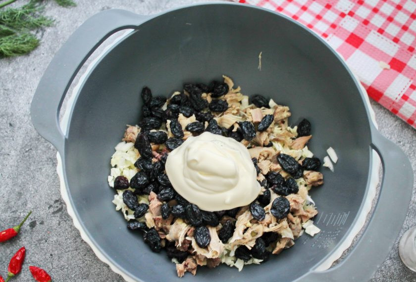 1. Этап. Салат с курицей в грейпфруте: Добавьте в салат изюм, заправьте майонезом, посолите и перемешайте.