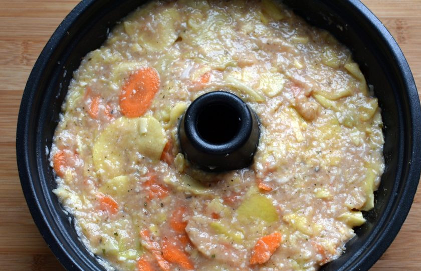 1. Этап. Запеканка-кугель из овощей с индейкой: Форму для кекса с отверстием в середине смажьте маслом и присыпьте сухарями. Выложите фарш с овощами в форму и разровняйте поверхность запеканки.