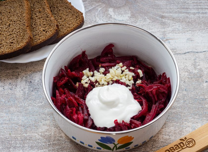 1. Этап. Бутерброды с селедкой на черном хлебе: Натрите свеклу на терке, добавьте рубленый мелко чеснок и сметану. Перемешайте и посолите по вкусу.