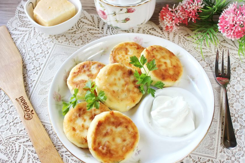 1. Этап. Сырники с твердым сыром и зеленью: Переложите сырники с твёрдым сыром и зеленью в тарелку. Подавайте горячими со сметаной.