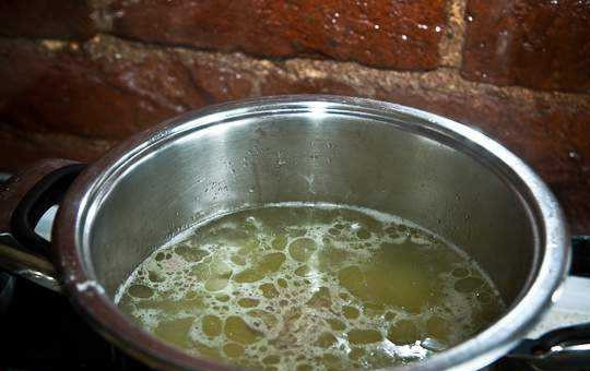 1. Этап. Вкусный рассольник: Тем временем процеженный бульон поставьте на огонь. Доведите его до кипения, а потом добавьте кусочки курицы и картофель. Варите суп 15 минут.