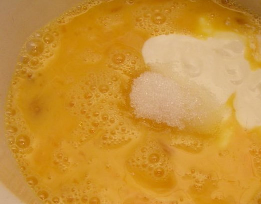 1. Этап. Творожные шарики, жареные в масле: Яйца взбиваем с сахаром и сметаной, потом вливаем аккуратно топленое масло. Перемешиваем.