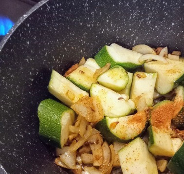 1. Этап. Карри из цуккини и белой фасоли: На сковороде на очень сильном огне разогреть масло и добавить зиру, листья карри и горчицу. Готовить 30 секунд. Затем добавить лук, чеснок, цуккини и перец чили. Жарить 2 минуты, постоянно помешивая. Добавить куркуму, соль и перец. Продолжать готовить ещё 4 минуты.