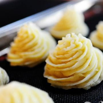 1. Этап. Картофель Герцогиня: 4. Выложить картофельную смесь в большой кондитерский мешок с наконечником в виде звезды и выдавить картофельное пюре на противень, двигаясь по спирали.