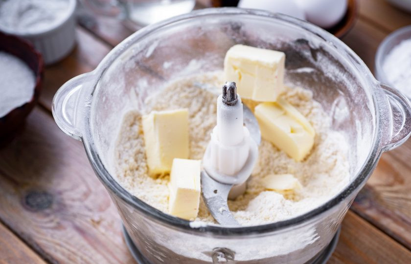 1. Этап. Пирог с замороженной вишней и безе: В чашу блендера высыпите всю муку, добавьте соль, ледяное масло, нарезанное кусочками. Запустите устройство примерно на одну минуту.