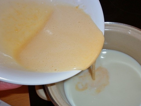 1. Этап. Торт Легкий: В горячее молоко аккуратно введите желтки с сахаром, не снимая его с плиты. Постоянно помешивая, доведите массу до кипения, томите на маленьком огне, пока крем не загустеет.