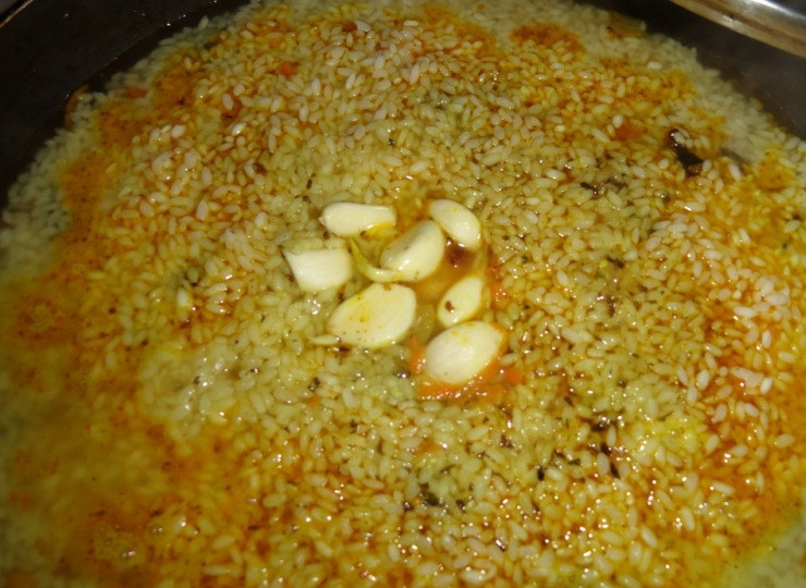 1. Этап. Плов с черносливом: Стакан воды солим (вода должна быть более соленая, чем готовое блюдо) и аккуратно вливаем в сковороду. Жидкость должна подниматься над рисом на пол сантиметра. Когда вода закипит, уменьшаем температуру и помещаем в средину сковороды зубчики чеснока.