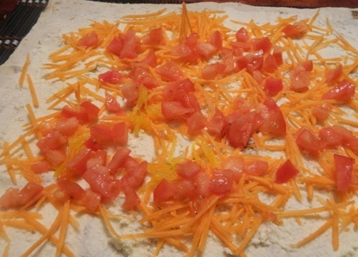 1. Этап. Овощной рулет из лаваша с адыгейским сыром: Сверху посыпаем морковкой и выкладываем кусочки помидора.