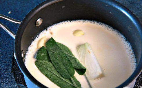 1. Этап. Ньокки из сладкого картофеля с сырным соусом: 7. Тем временем приготовить соус. В небольшой кастрюле смешать молоко, лук, чеснок и шалфей. Нагреть на среднем огне до появления маленьких пузырьков на поверхности, около 5 минут. Не доводите до кипения. Снять кастрюлю с огня и дать постоять 10 минут. Убрать из молока лук, чеснок и шалфей.