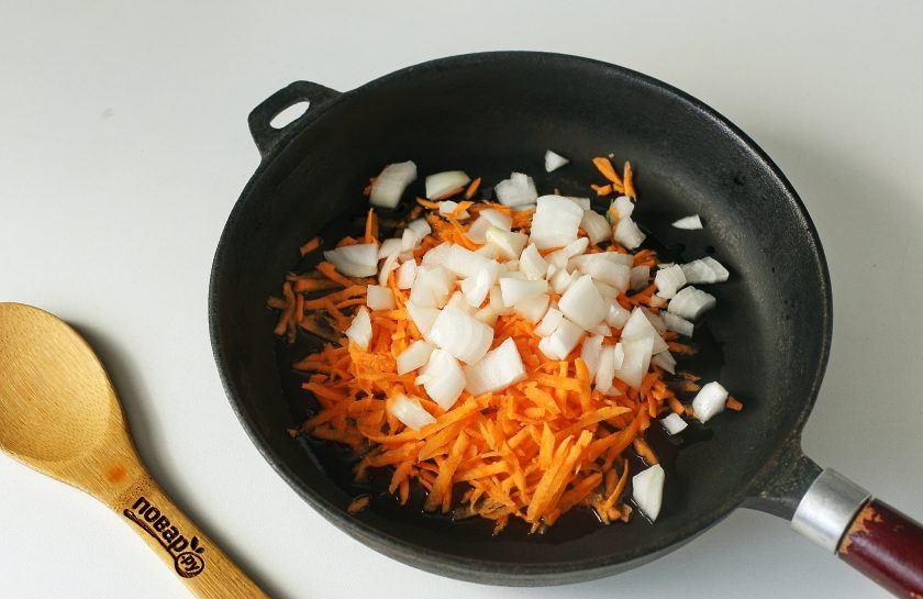 1. Этап. Борщ с аджикой: В сковороде разогрейте масло. Выложите тертую морковь и нарезанный кубиками лук.