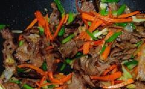 1. Этап. Говядина по-сычуаньски: Кидаем зеленый лук и имбирь. Жарим 2-3 минуты.