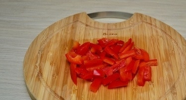 1. Этап. Курица с рисовой лапшой и соевым соусом: 4. Помойте, очистите перец от сердцевины и нарежьте тонкими пластинами.