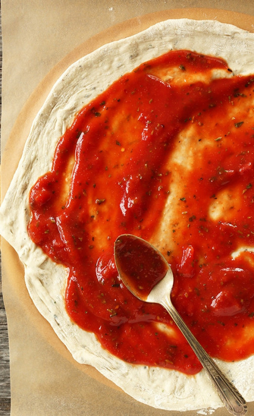 1. Этап. Вегетарианская пицца: На противень положить бумагу для выпечки. Тесто для пиццы тонко раскатать на бумаге, томатный соус распределить равномерно по поверхности пиццы, посыпать специями.