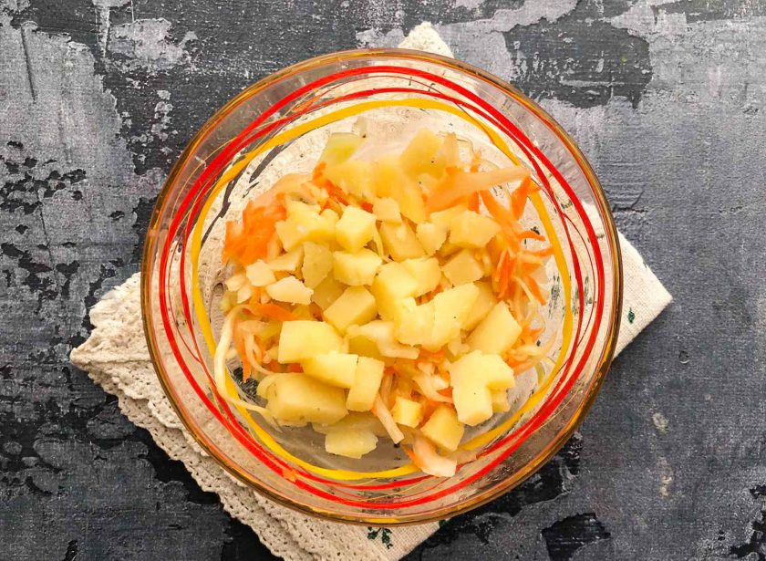 1. Этап. Салат с квашеной капустой и ветчиной: Вареный картофель очистите от кожуры, нарежьте небольшими кубиками и добавьте к капусте.