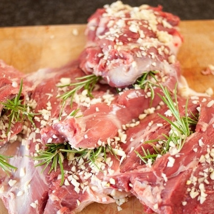 1. Этап. Баранья нога на гриле: 3. Чеснок очистите и очень мелко изрубите. Розмарин промойте, снимите с веточек листочки или просто веточки измельчите. Начините кармашки на бараньей ноге смесью из розмарина и чеснока, хорошенько присыпьте пряностями и всю поверхность баранины.