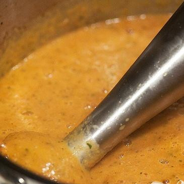 1. Этап. Суп с запеченным чесноком, помидорами и сыром: 7. Добавить тертый сыр Пармезан. Используя погружной блендер, перемешать суп до консистенции пюре. Вы также можете сделать это в обычном блендере. Добавить соль и черный перец по вкусу, если необходимо.