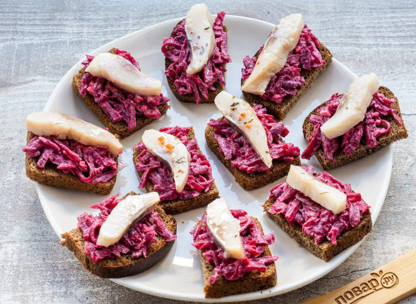 1. Этап. Бутерброды с селедкой на черном хлебе: Сверху на каждый бутерброд выложите по кусочку филе сельди.