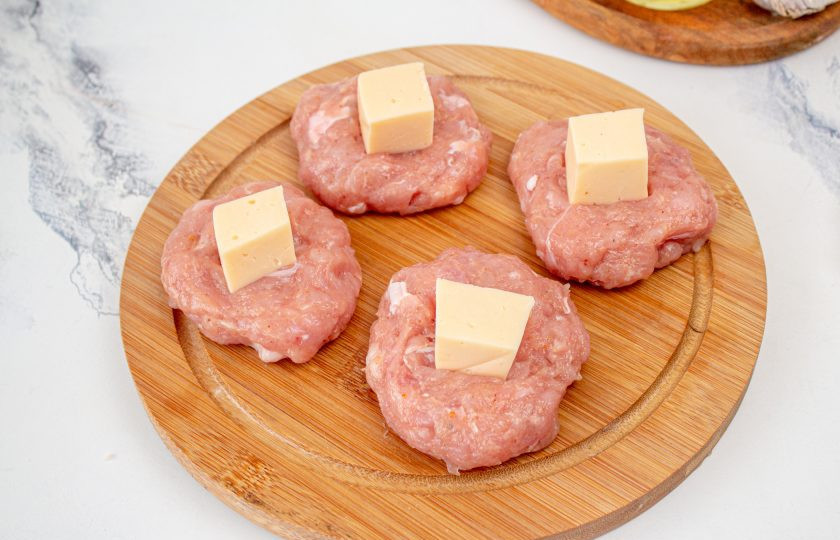 1. Этап. Куриные котлеты с сыром в мультиварке: Сыр разделите на равные 7 частей. Каждый кусочек сыра выложите на середину лепешки из фарша.