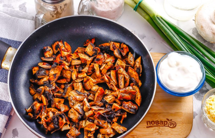 1. Этап. Пельмени по-царски: Шампиньоны нарежьте кубиками, ломтиками и обжарьте на растительном масле в сковороде. Если вместо зеленого лука вы будете использовать репчатый, то его также обжарьте вместе с грибами.
