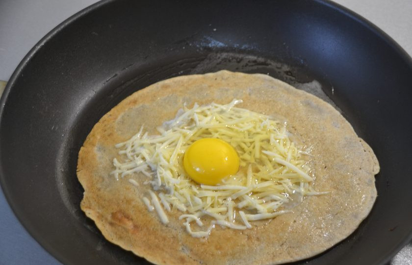 1. Этап. Яичница в блинах: Разместите яйцо в центре окружности из сыра.