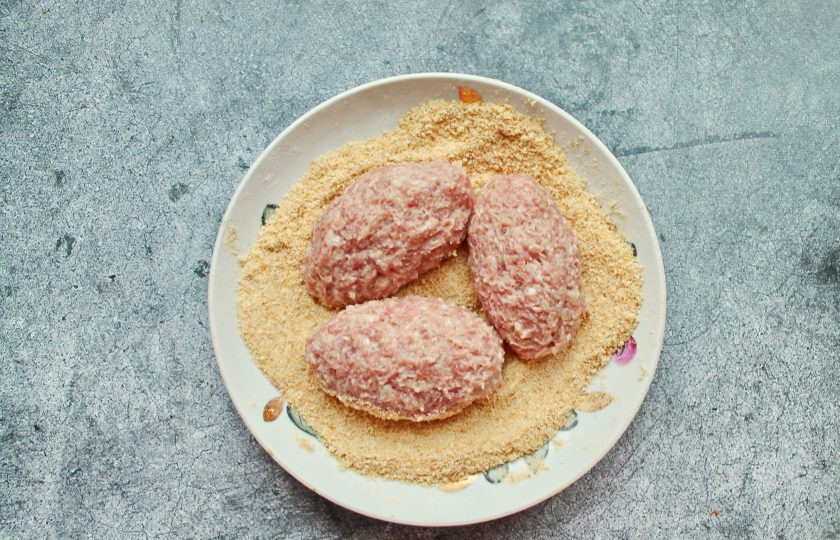 1. Этап. Котлеты из косули: Влажными руками разделите фарш на части и сформируйте котлеты. Полностью обваляйте их в панировочных сухарях.